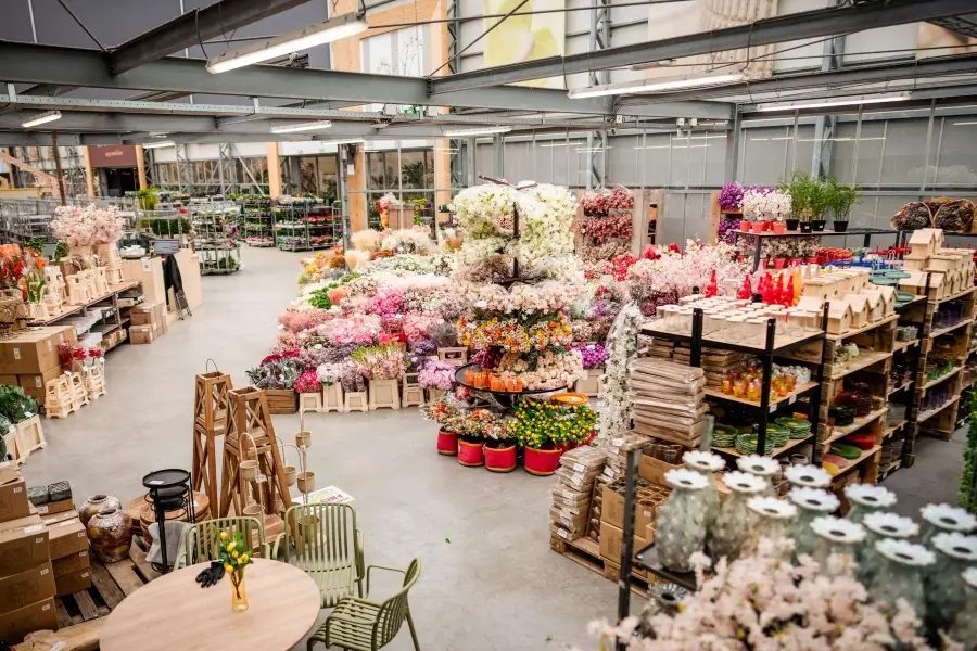 showroom hal vol met seizoen zijden bloemen. De kunstbloemen staan in emmers uitgestald.